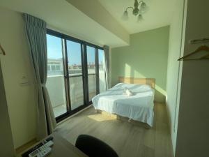 a bedroom with a bed and a large window at 哈樓民宿二館 in Lukang