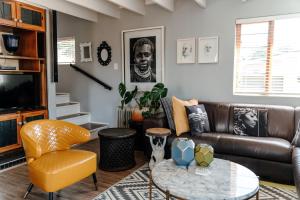 a living room with a leather couch and a table at The Red Door in Clarens