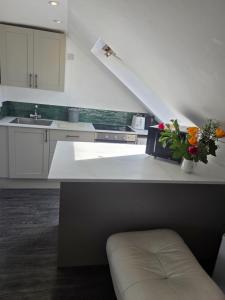 a kitchen with a white counter with flowers on it at The Fox Apartment LBA in Horsforth