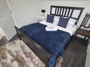 a bedroom with a large bed with blue sheets and pillows at The Fox Apartment LBA in Horsforth