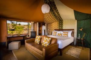 a bedroom with a bed and a couch and a television at Mahali Mzuri in Aitong