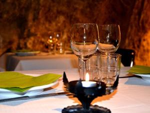 two wine glasses sitting on a table with a candle at Cal Valeriet in Montsonis