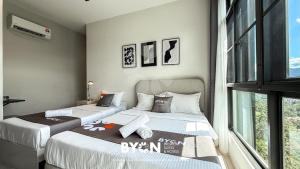 two beds sitting next to each other in a bedroom at Enclave Nature Suites Bukit Tinggi by BYON in Bentong