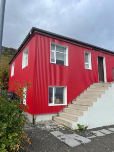 a red house with stairs in front of it at Summerhouse by the ocean in Drangsnes