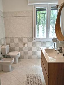 a bathroom with a toilet and a sink and a mirror at B&B La stanza del sole in Modena