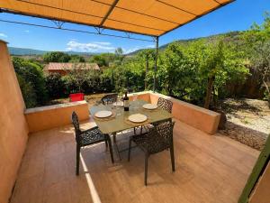 a table and chairs on a patio with an umbrella at Gîte du salagou in Octon