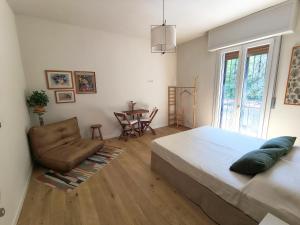 a bedroom with a bed and a chair and a table at B&B La stanza del sole in Modena