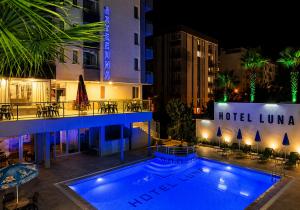 a view of a hotel with a swimming pool at night at Luna Hotel in Antalya