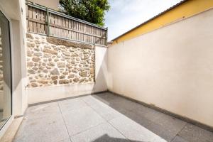 a garage with a stone wall and a sidewalk at Barcelos Center in Barcelos +47 photos