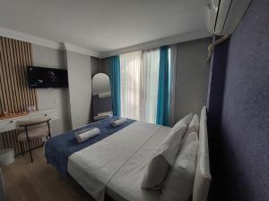a bedroom with a large bed and a desk at dolunaydın hotel in Side +49 photos
