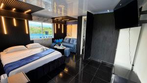 a bedroom with a bed and a couch in it at Arte Hotel del Quindío in Filandia
