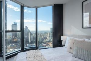 a bedroom with a bed with a view of a city at LaneStay - 2BR Panoramic Views w Pool Spa & Gym in Melbourne