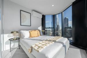 a bedroom with a white bed with a large window at LaneStay - 2BR Panoramic Views w Pool Spa & Gym in Melbourne