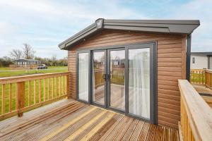 a small cabin with glass doors on a deck at Host & Stay - Stag Lodge in Pickering