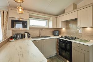 a kitchen with a sink and a stove at Host & Stay - Stag Lodge in Pickering
