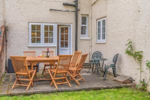 a wooden table and chairs in front of a house at 4 Bed in Lyndhurst oc-nfl57 in Lyndhurst