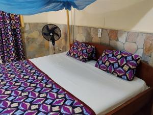ein Schlafzimmer mit zwei Betten und einem Ventilator in der Unterkunft Hôtel Bellevue in Natitingou