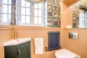 a bathroom with a sink and a toilet and a window at 4 Bed in Lyndhurst oc-nfl57 in Lyndhurst +24 photos