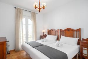 a bedroom with a large bed and a chandelier at Atlantico Atico PLUS by Ĥ - Playa Punta del Moral PAHT76P102 in Isla del Moral +27 photos