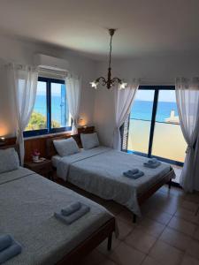 a bedroom with two beds and a view of the ocean at Kanalli Apartments in Pomos