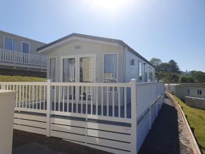 a tiny house with a white picket fence at Devon holiday in Goodrington