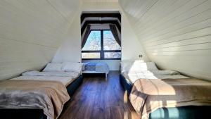 three beds in a room with a window at Meziad-Panorama in Meziad