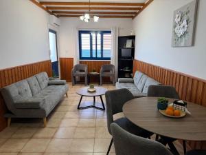a living room with couches and a table and chairs at Kanalli Apartments in Pomos