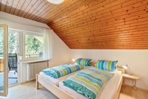 a bedroom with a wooden ceiling and a bed with pillows at Spinnertonihof in Bad Peterstal