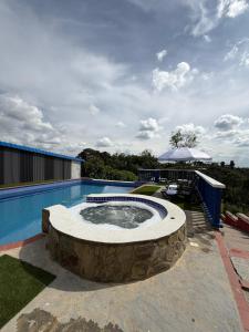 a large swimming pool with a stone fountain in a yard at Arte Hotel del Quindío in Filandia +24 photos