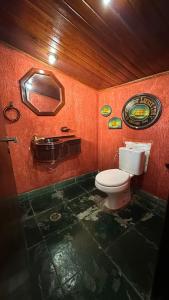 a red bathroom with a toilet and a sink at Casa Aparecida in Aparecida