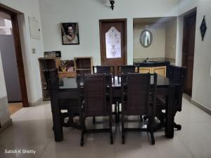 a dining room with a table and chairs at Rajmata Nivas in Kaup +2 photos