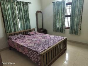 a bedroom with a bed and a mirror and windows at Rajmata Nivas in Kaup