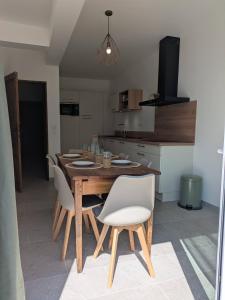 a kitchen with a wooden table and white chairs at Villa Salesiae in Les Salles-sur-Verdon +19 photos