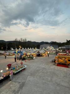 an outdoor market with vegetables and vendors in a parking lot at Jupiter Hostel in Ban Khlong Haeng