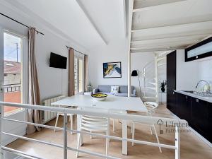 a white dining room with a white table and chairs at Spacieux triplex avec vue mer, proche de Monaco, 54 m2 in Cap d'Ail