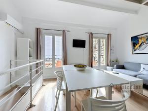 a white living room with a table and a couch at Spacieux triplex avec vue mer, proche de Monaco, 54 m2 in Cap d'Ail
