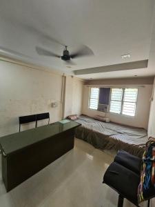 a room with a desk and a bed and a couch at Homenest Stay in Nashik