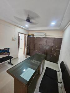 a room with a desk and a table and a chair at Homenest Stay in Nashik