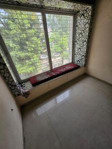 an empty room with two windows and a tiled floor at Homenest Stay in Nashik