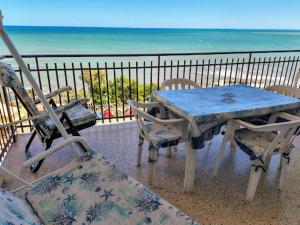 a table and chairs on a balcony with the beach at Levante home in Trani
