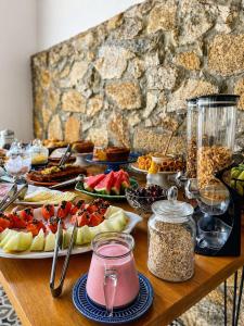 a table topped with plates of food and fruit at Pousada Villa Tiradentes Suítes - Centro in Tiradentes