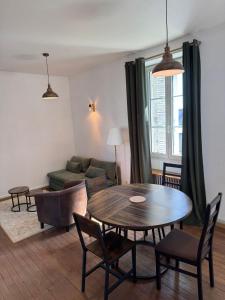 a living room with a table and a couch at Cocon urbain avec jardin - appartement proche hôpital in Angers
