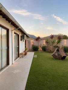 a backyard with a patio and a lawn at Pousada Villa Tiradentes Suítes - Centro in Tiradentes