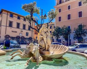 a fountain in a city with two horses in it at Bouganville House in Nettuno