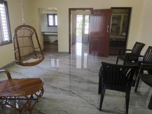 a living room with chairs and a swing at Raja Accommodation in Kovilpatti