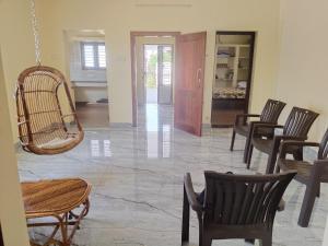 a living room with chairs and a hanging chair at Raja Accommodation in Kovilpatti +18 photos