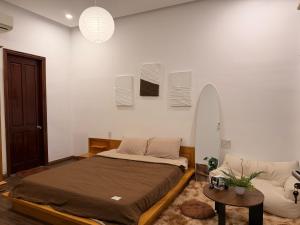 a bedroom with a large bed and a couch at Lita Homestay in Thôn Trường Giang