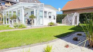 a white house with a yard with a lawn sidx sidx sidx at Stettiner Str 6c in Grömitz