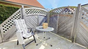 a patio with a table and chairs and a fence at Stettiner Str 6c in Grömitz +13 photos