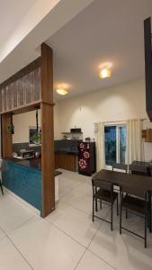 a living room with a table and a kitchen at Sunset Villa in Mysore